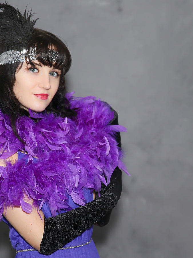 20er Jahre Mode, Frau im lila Charlestonkleid mit Kopfschmuck und langen Handschuhen