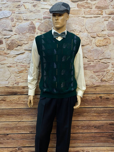 Komplettes Vintage-Herren-Outfit der 20er Jahre: cremefarbenes Hemd, schwarze Bundfaltenhose, dunkelgrüner Pullunder, graue Fliege und Patchwork-Schiebermütze.