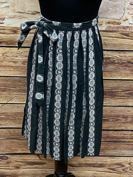 Schwarze Vintage Dirndl-Schürze für Damen mit weißen Ranken, 63 cm lang, aus Baumwoll-Mischgewebe, Schleifenverschluss, sehr guter Zustand.