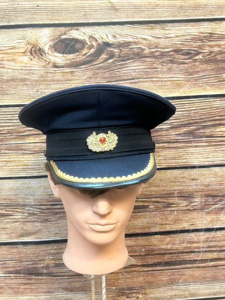 Vorderansicht einer blauen NVA Offiziers-Schirmmütze mit DDR-Abzeichen.