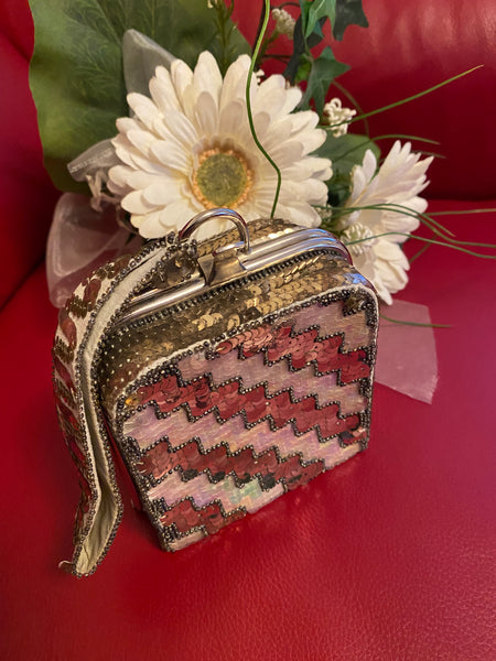 Quadratische Vintage-Minaudière (10 × 10 × 5 cm) in Zick-Zack-Pailletten aus Pastell- und Silber-Tönen, silberner Metallbügel, kurzer Handgelenkriemen, 1920er-/30er-Jahre.