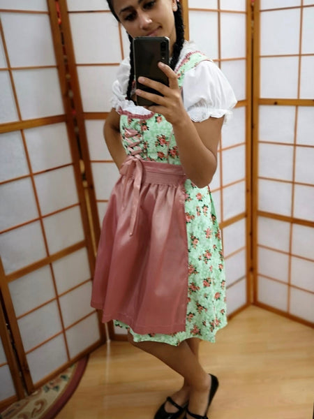 Dirndl getragen: mintgrünes Rosen-Dirndl mit rosa Schürze; Bluse nur zu Demonstrationszwecken, nicht enthalten.