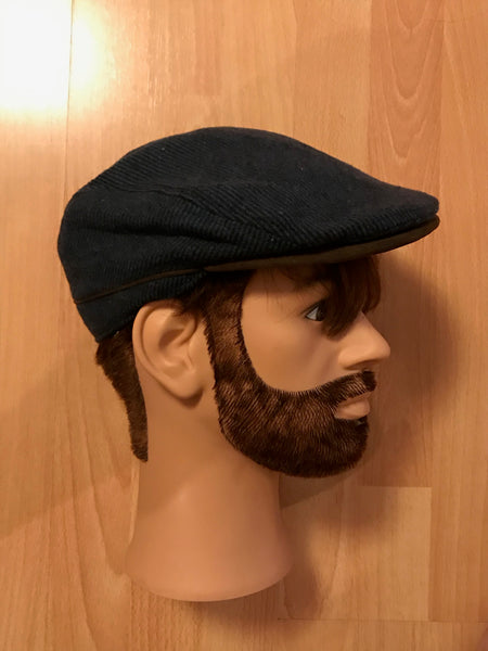 Seitenansicht einer dunkelblauen Schiebermütze im 20er Jahre Stil auf einem Herren-Schaufensterkopf.