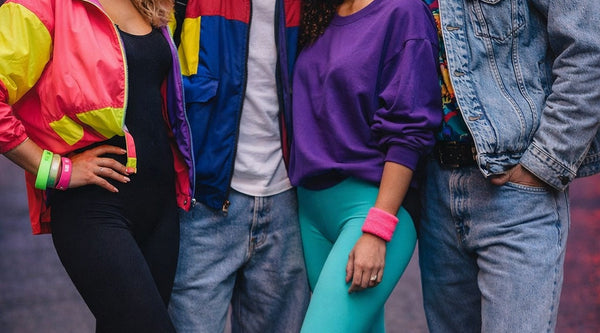 „80er Jahre Mode mit bunten Neon Outfits für Damen und Herren im typischen Retro Stil der 1980er Jahre“