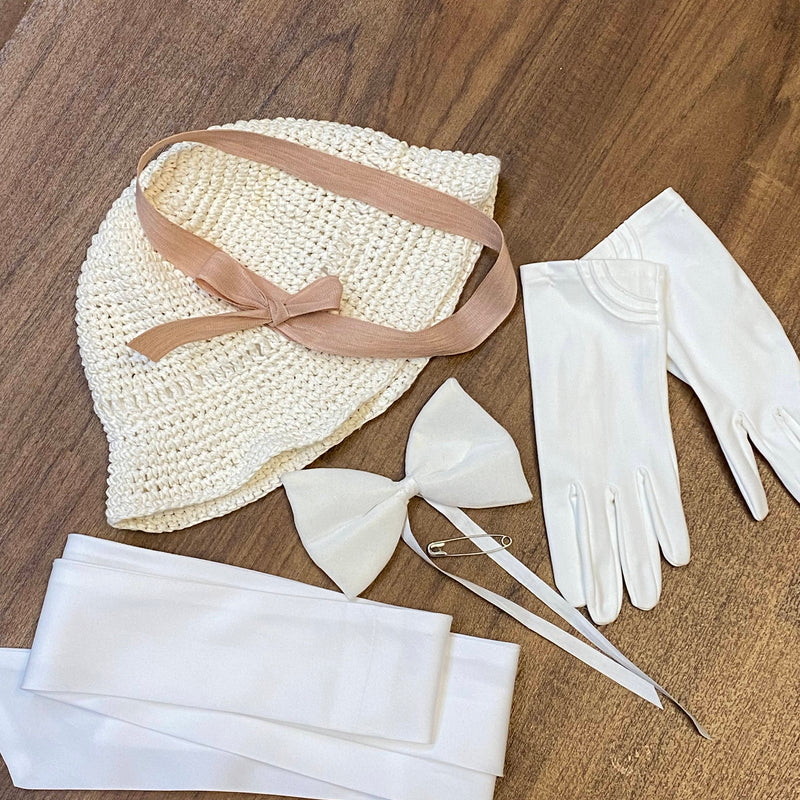 „Accessoires zum Oldtimer-Fahrt Outfit mit hellem Hut, weißen Handschuhen und weißem Taillenband“