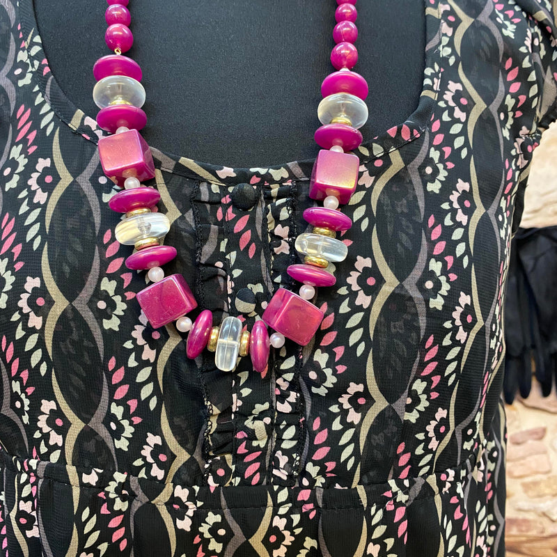 „Detailansicht vom Downton Abbey Kleid mit pinkfarbener Statement-Kette und dekorativem Ausschnitt“