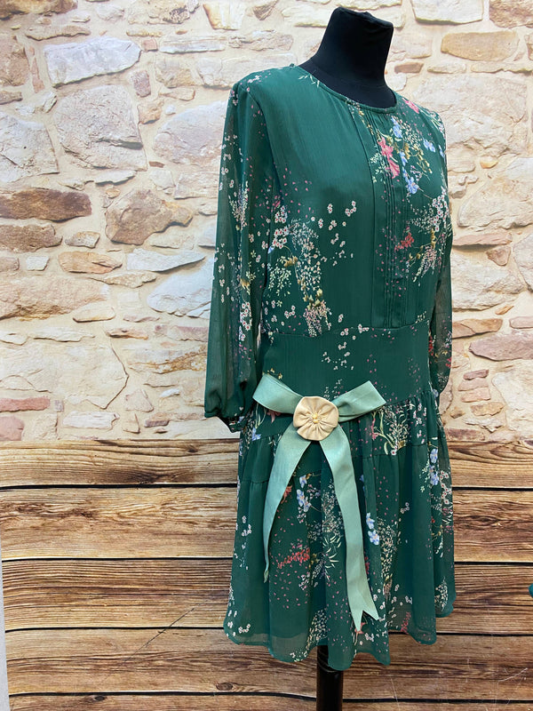 „Grünes florales Tageskleid im 1920er Jahre Stil mit tiefer Taille und passendem Vintage-Hut“