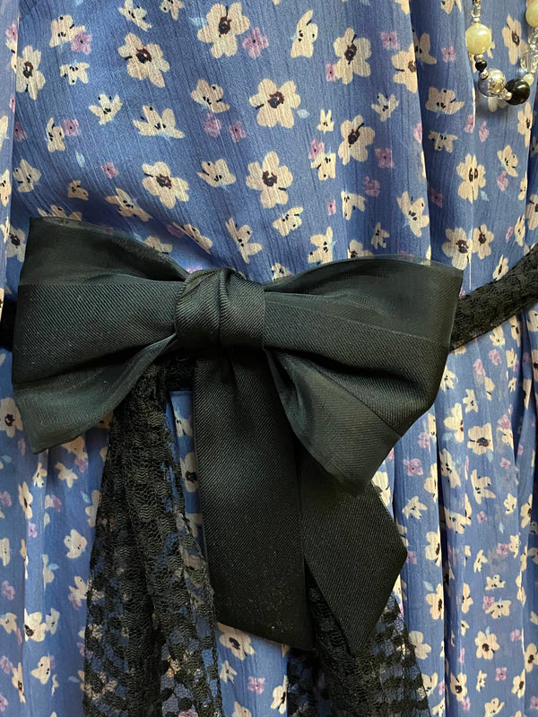 „Schwarzer Gürtel mit großer Schleife und Spitzenband als Accessoire zum blauen Retro Gartenparty Kleid“