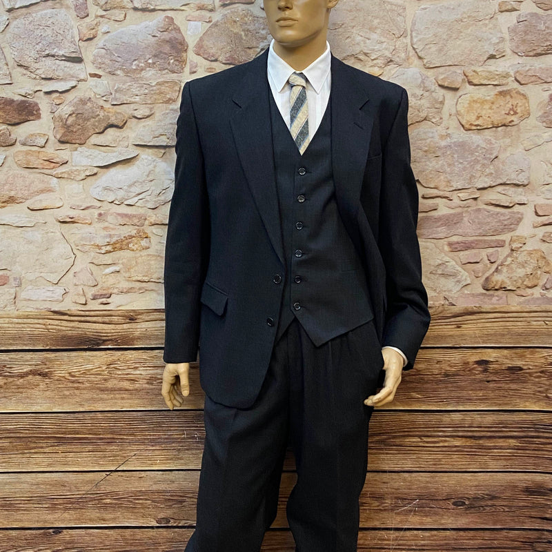 „Vintage Herrenset im 20er Jahre Stil mit anthrazitfarbenem Wollanzug, Weste, Bundfaltenhose, weißem Hemd, Wollkrawatte und Tweed-Schiebermütze.