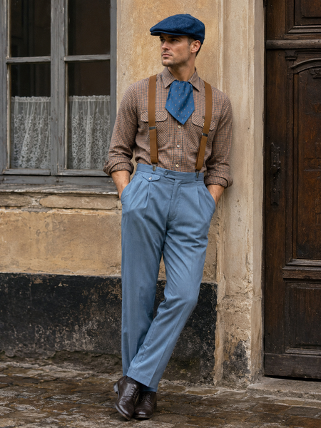KI-generiertes Bild eines Herren-Outfits im 20er-Jahre-Stil mit karierter Wrangler-Hemdbluse, blaugrauer Hose, braunen Hosenträgern, blauer Schal-Krawatte und blauer Schiebermütze