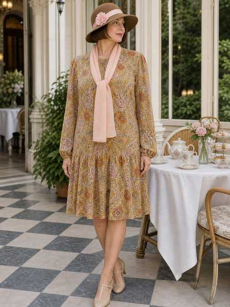 Dame in 20er High Tea Kleid Gr. 44 mit braunem Hut und rosafarbenem Schal in eleganter Teehaus-Umgebung