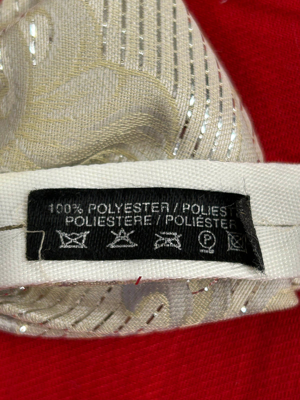 Detailaufnahme der cremefarbenen Fliege mit eingewebtem Muster und Materialetikett 100 % Polyester