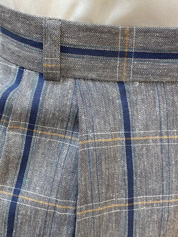 „Stoffdetail der Knickerbocker: graues Gewebe mit blauen und ockerfarbenen Karos