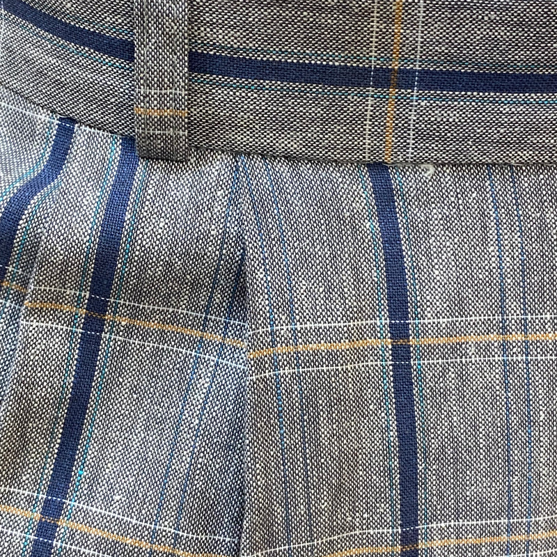 „Stoffdetail der Knickerbocker: graues Gewebe mit blauen und ockerfarbenen Karos