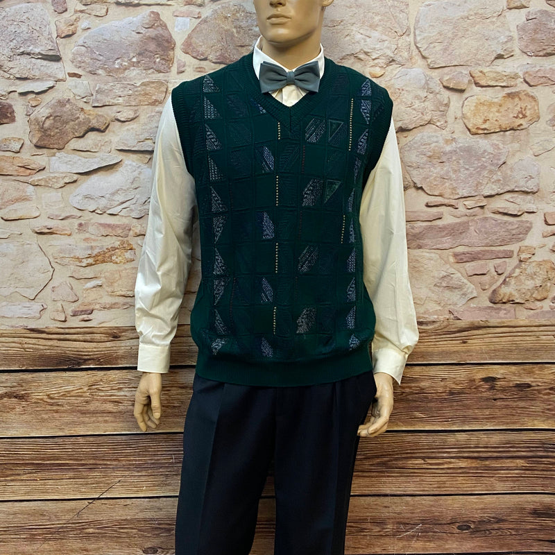 Komplettes Vintage-Herren-Outfit der 20er Jahre: cremefarbenes Hemd, schwarze Bundfaltenhose, dunkelgrüner Pullunder, graue Fliege und Patchwork-Schiebermütze.