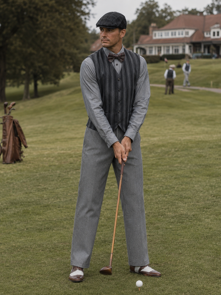 „Echtes Model im grauen 20er Jahre Herren Outfit mit Weste, Schiebermütze und Fliege beim Hickory Golf auf historischem Golfplatz“