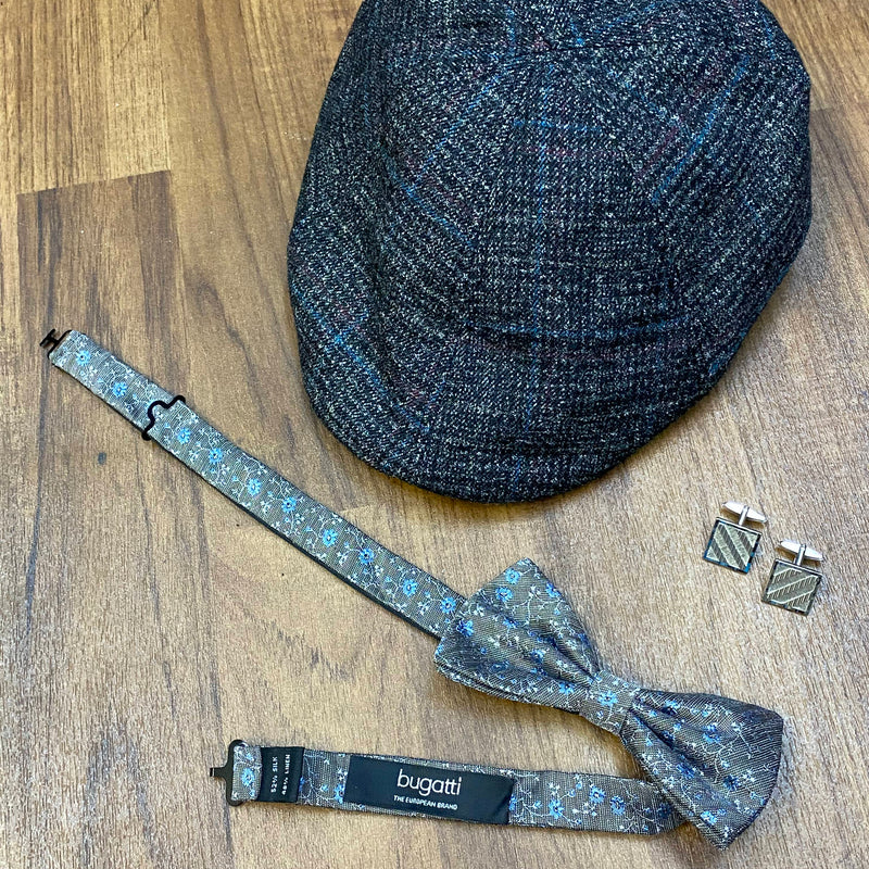 Schiebermütze, Fliege und Manschettenknöpfe als Accessoires für Vintage Herren Outfit