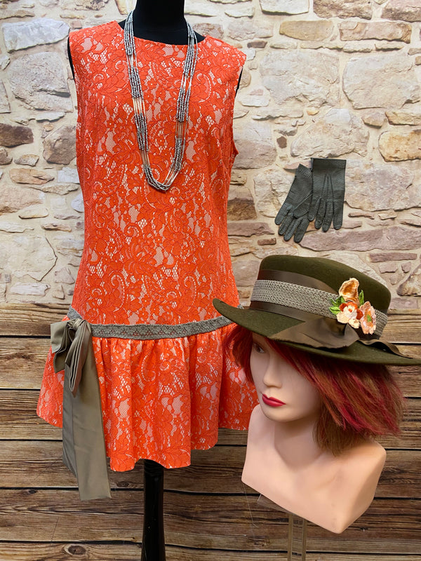 „20er Jahre Damen Outfit mit orangefarbenem Drop-Waist Spitzenkleid Gr. 42, Vintage Hut, Lederhandschuhen und Kette“