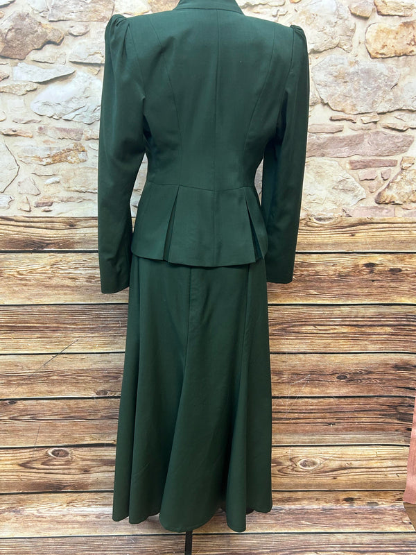 „Rückenansicht vom 20er-Jahre Damenkostüm aus hochwertiger Wolle in Smaragdgrün mit Spitzenbluse, Rock, Blazer, Handschuhen und Fascinator, Größe 36/38.