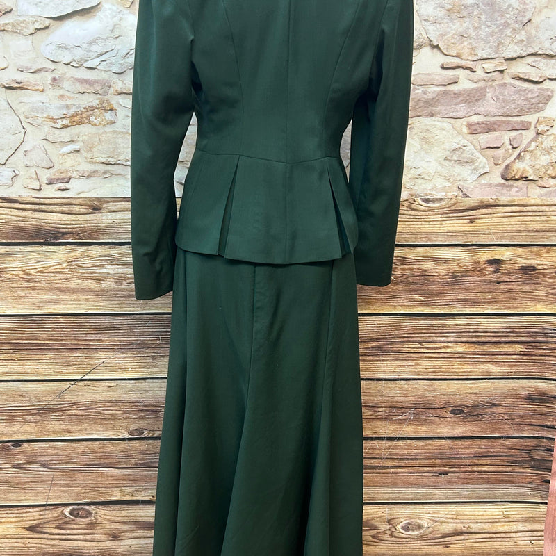 „Rückenansicht vom 20er-Jahre Damenkostüm aus hochwertiger Wolle in Smaragdgrün mit Spitzenbluse, Rock, Blazer, Handschuhen und Fascinator, Größe 36/38.