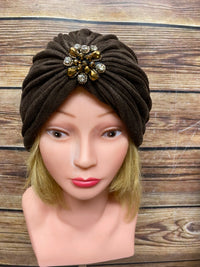 Style années 20 pour la dame, turban marron avec broche élégante et collier de perles