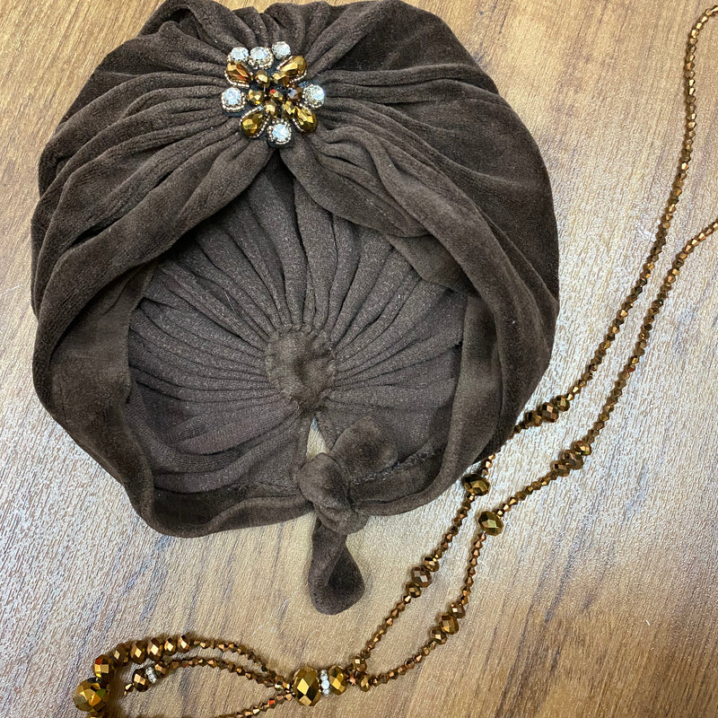 20er Styling für die Lady, brauner Turban mit eleganter Brosche und Perlenkette