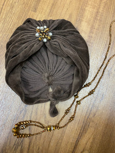20er Styling für die Lady, brauner Turban mit eleganter Brosche und Perlenkette