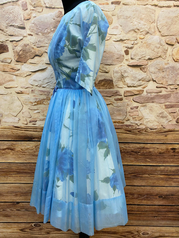 „Seitliche Ansicht vom originalen Vintage Blumenkleid der 50er Jahre in Hellblau mit ausgestelltem Rock“