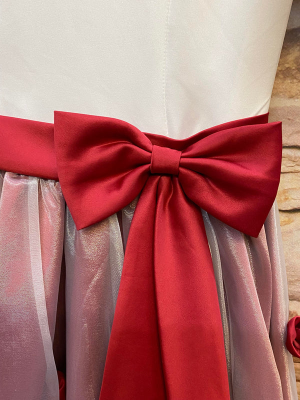 „Detailansicht vom roten Taillengürtel mit großer Schleife an festlichem 50er Jahre Kleid“