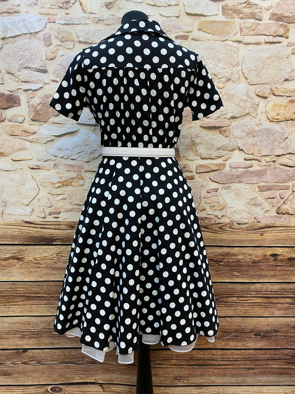 „Rückansicht vom schwarz weißen Polka Dot Kleid im 50er Jahre Stil mit kurzem Arm und Gürtel“