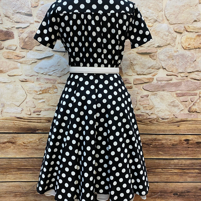 „Rückansicht vom schwarz weißen Polka Dot Kleid im 50er Jahre Stil mit kurzem Arm und Gürtel“