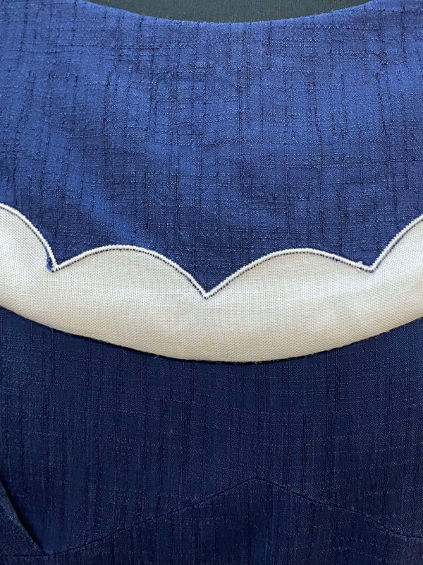 „Detailansicht vom 50er Jahre Vintage Matrosenkleid in Blau Weiß mit geschwungenem cremeweißem Ausschnittbesatz“