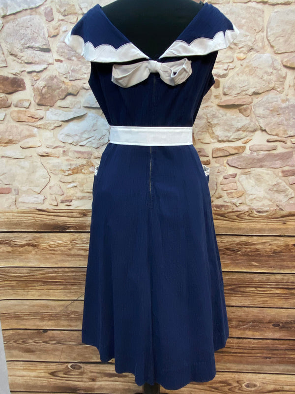 „Rückansicht des originalen 50er Jahre Vintage Kleides in Marineblau mit cremeweißer Schleife und Gürtel“