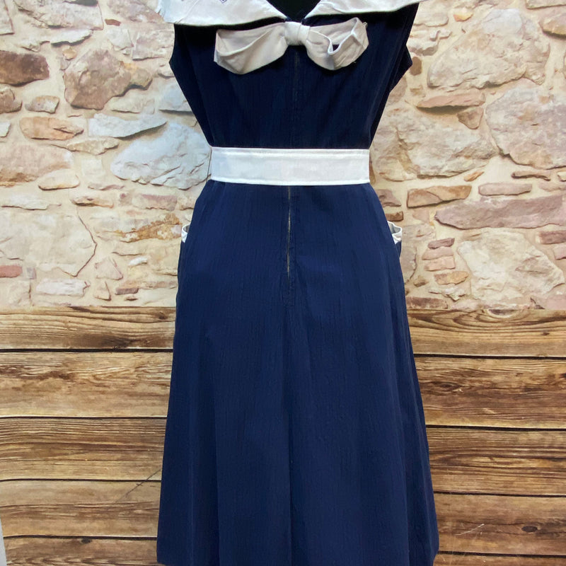 „Rückansicht des originalen 50er Jahre Vintage Kleides in Marineblau mit cremeweißer Schleife und Gürtel“