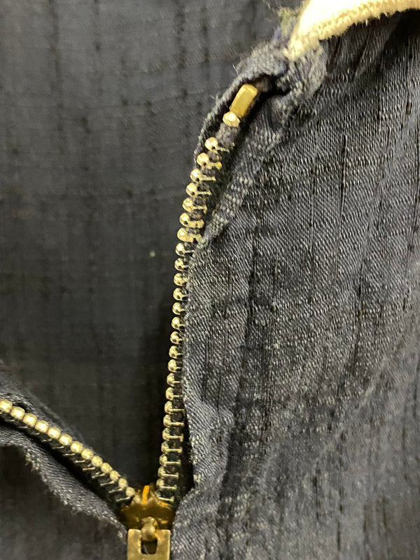 „Nahaufnahme des Metallreißverschlusses am originalen handgefertigten 50er Jahre Kleid in Marineblau“