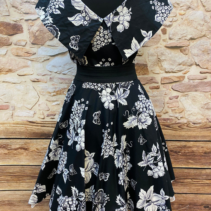 „Rückansicht vom 50er Jahre Kleid schwarz weiß mit Früchteprint und ausgestelltem Rock“