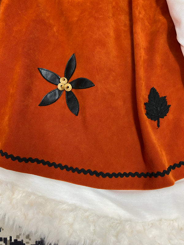 „Vintage 1970er Outfit mit gemusterter Schlaghose und orangefarbener Bluse“