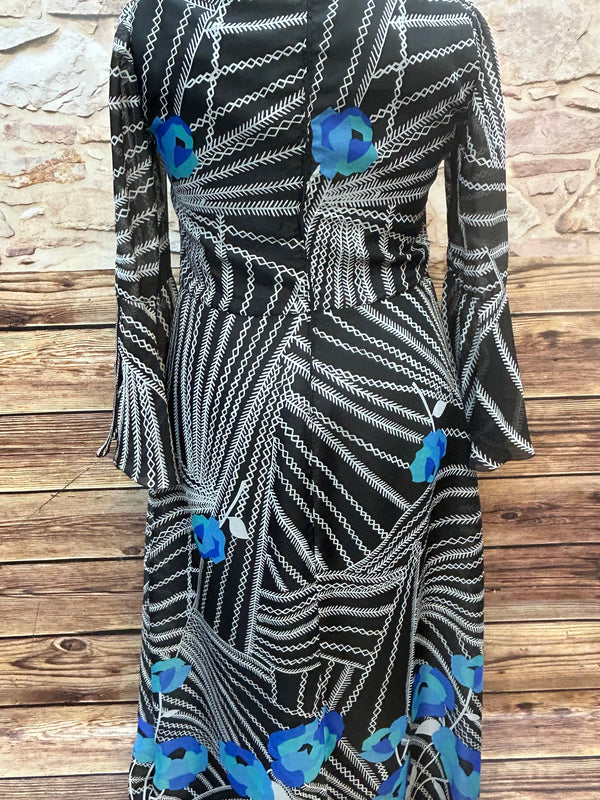 „Rückansicht des 70er-Jahre Maxikleids mit Reißverschluss und Blumenmuster am Saum“