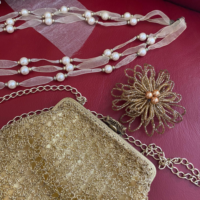 Lurex-Abendtasche, Perlenkette und Haarschmuck in gold