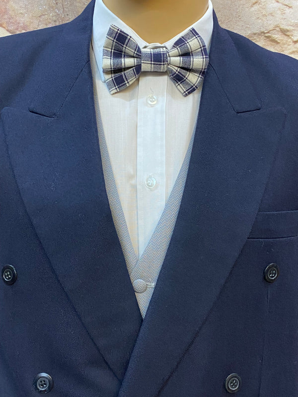 „Nahaufnahme Fliege kariert in Blau/Weiß und graue Weste zum dunkelblauen Sakko.