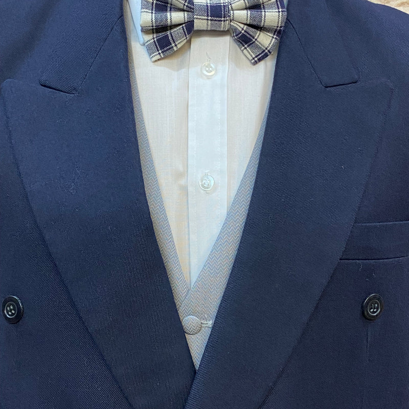 „Nahaufnahme Fliege kariert in Blau/Weiß und graue Weste zum dunkelblauen Sakko.