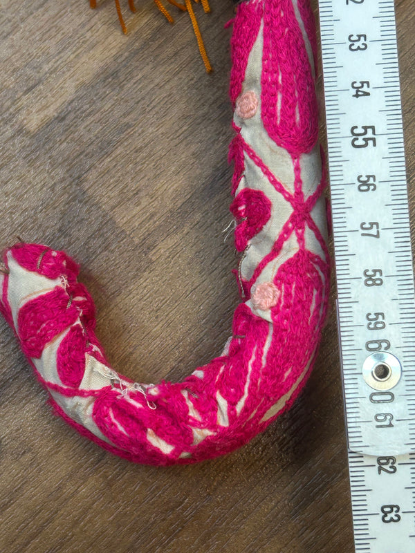 „Detailaufnahme gepolsterter Griff mit pinker Stoffstickerei des Vintage-Sonnenschirms“