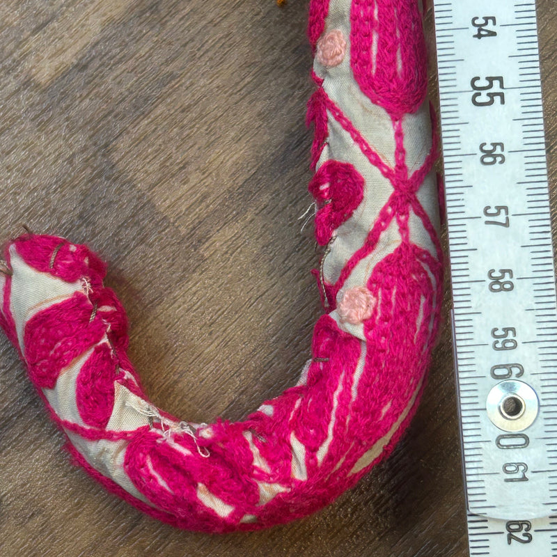 „Detailaufnahme gepolsterter Griff mit pinker Stoffstickerei des Vintage-Sonnenschirms“