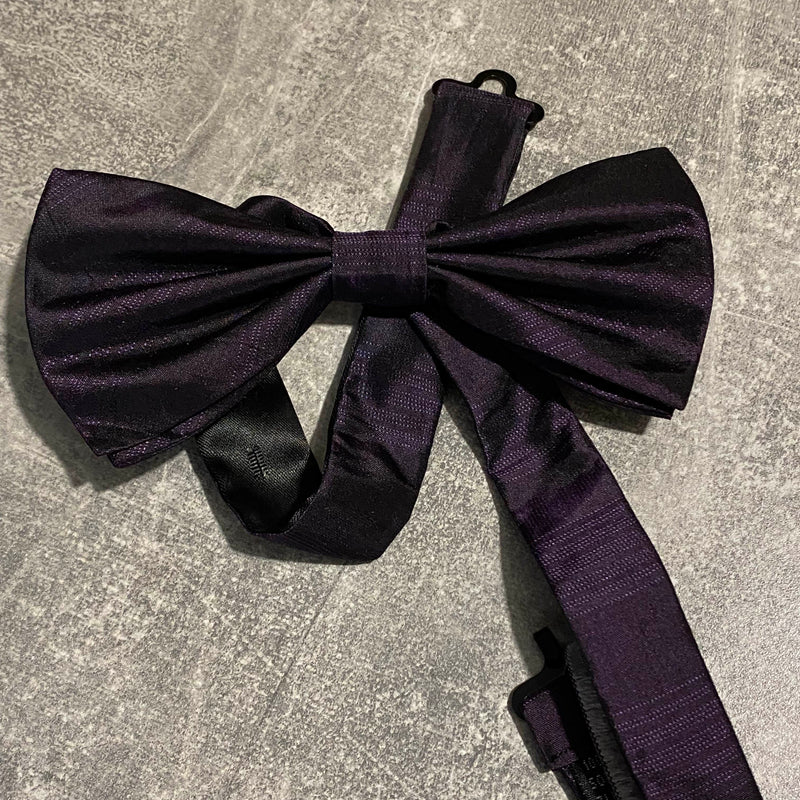 „Bugatti Herren Fliege aus violetter Seide – elegante Schleife auf grauem Hintergrund