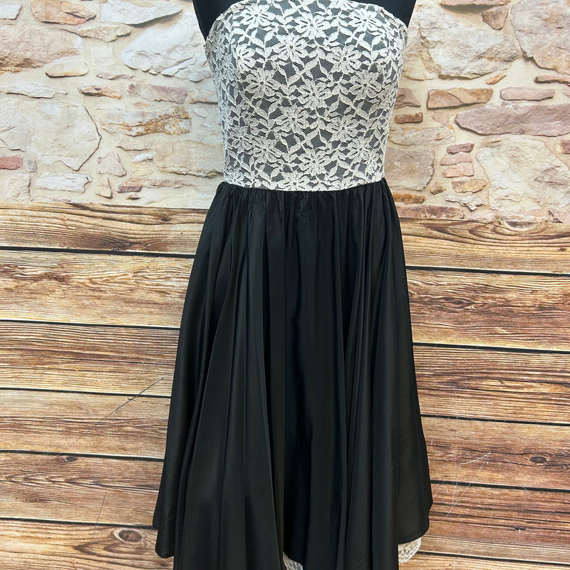 „Vintage Cocktailkleid Vera Mont in Größe 34, schulterfrei mit cremefarbener Spitze und schwarzem Tellerrock Vorderansicht“