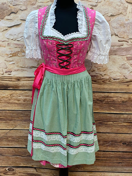 „Dirndl in Pink und Grün mit Schnürmieder und karierter Schürze, Vorderansicht auf Schneiderpuppe“