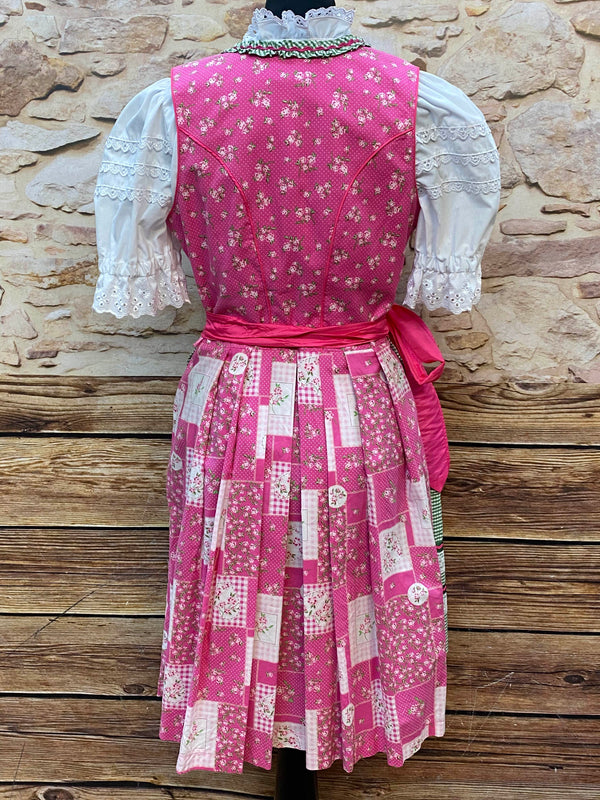 „Rückansicht des pink-grünen Dirndls mit Bindeschürze und floralem Muster“