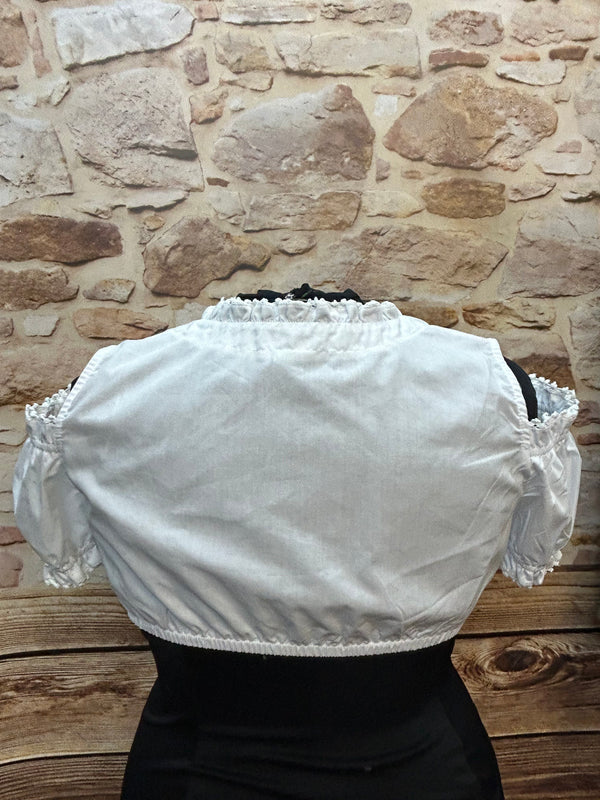 „Rückansicht einer weißen Dirndlbluse mit Spitzenkragen und Puffärmeln“