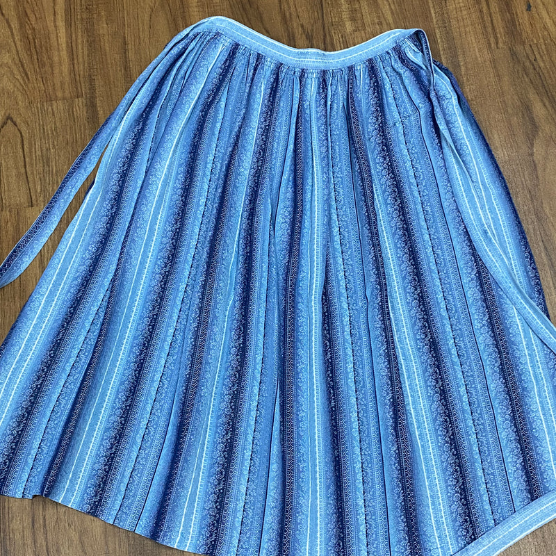 Blau gestreifte Vintage Dirndl-Schürze mit weißen und hellblauen Blumenranken, 68 cm lang, Baumwoll-Mischgewebe, Schleifenverschluss, sehr guter Zustand.