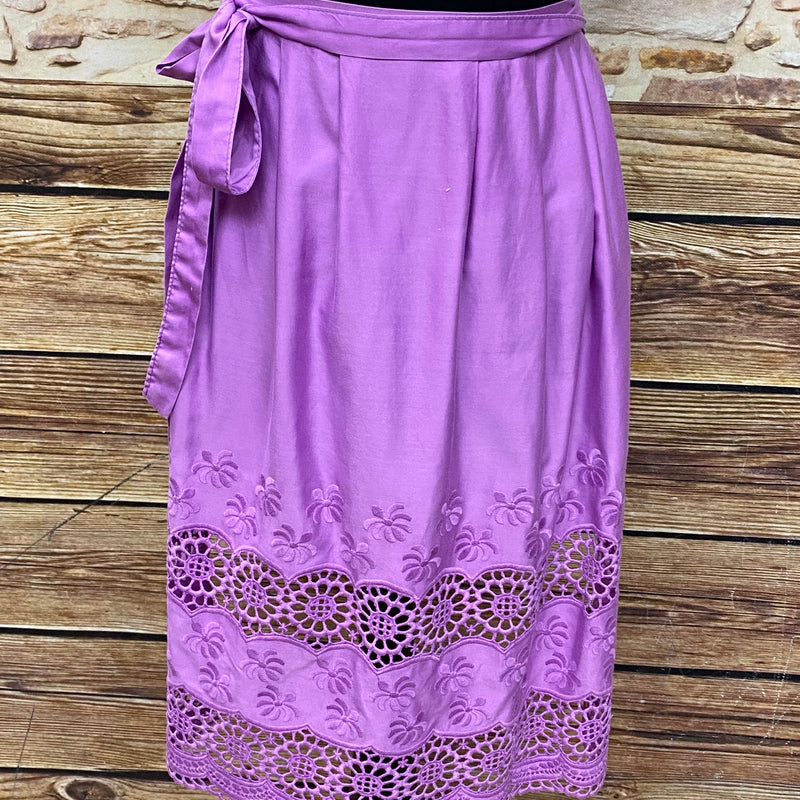 „Vintage Dirndlschürze lila mit floraler Lochstickerei und dekorativem Saum“